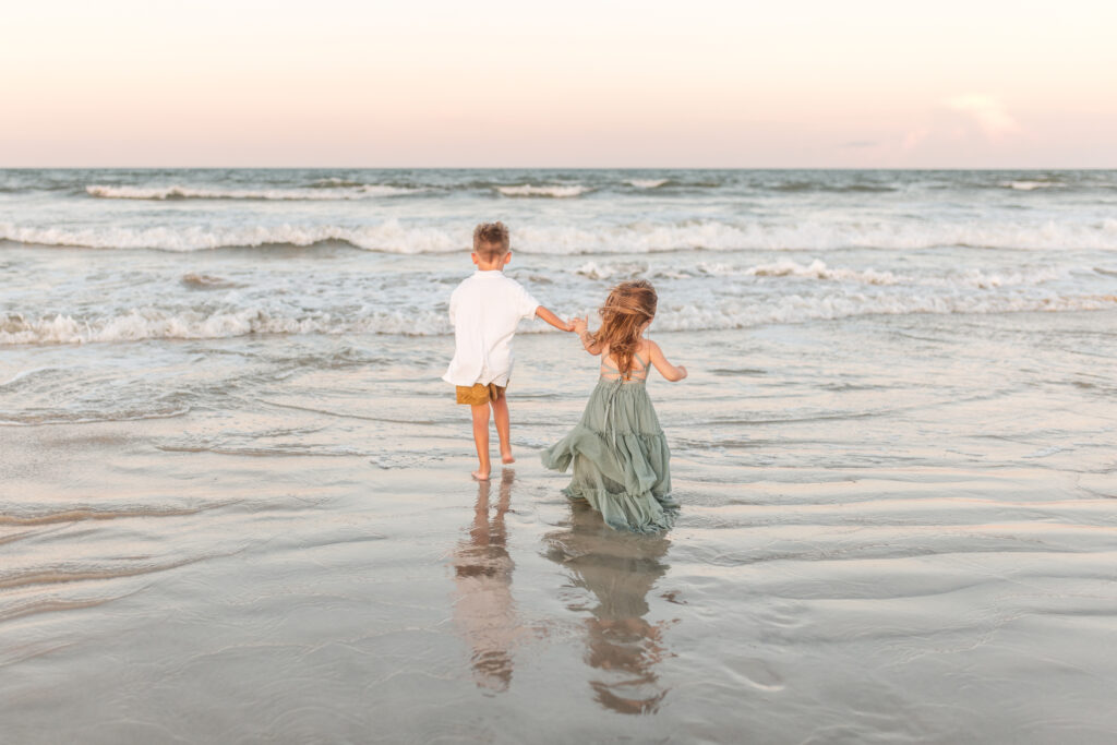 St. Augustine Family Photographer | Timeless Memories on Florida’s Historic Coast 3 Children laughing and playing in the waves at Vilano Beach during sunrise
